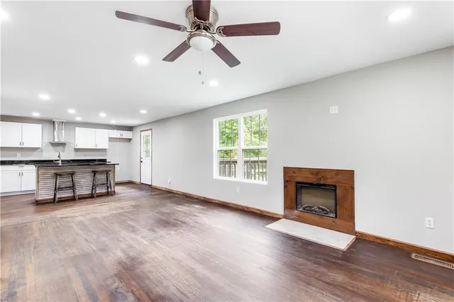 an empty room with windows and a ceiling fan