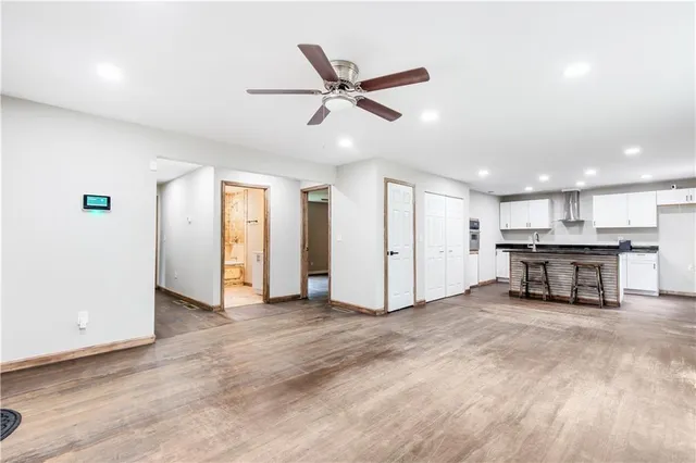 a kitchen with stainless steel appliances granite countertop a stove a sink and a refrigerator with wooden floors