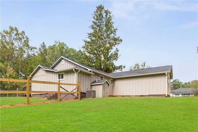 a white house that has a small yard and trees in front of it