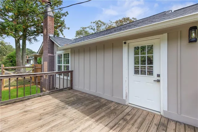 a view of an empty room with a window and a kitchen