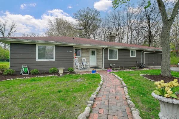 a front view of a house with a garden and yard