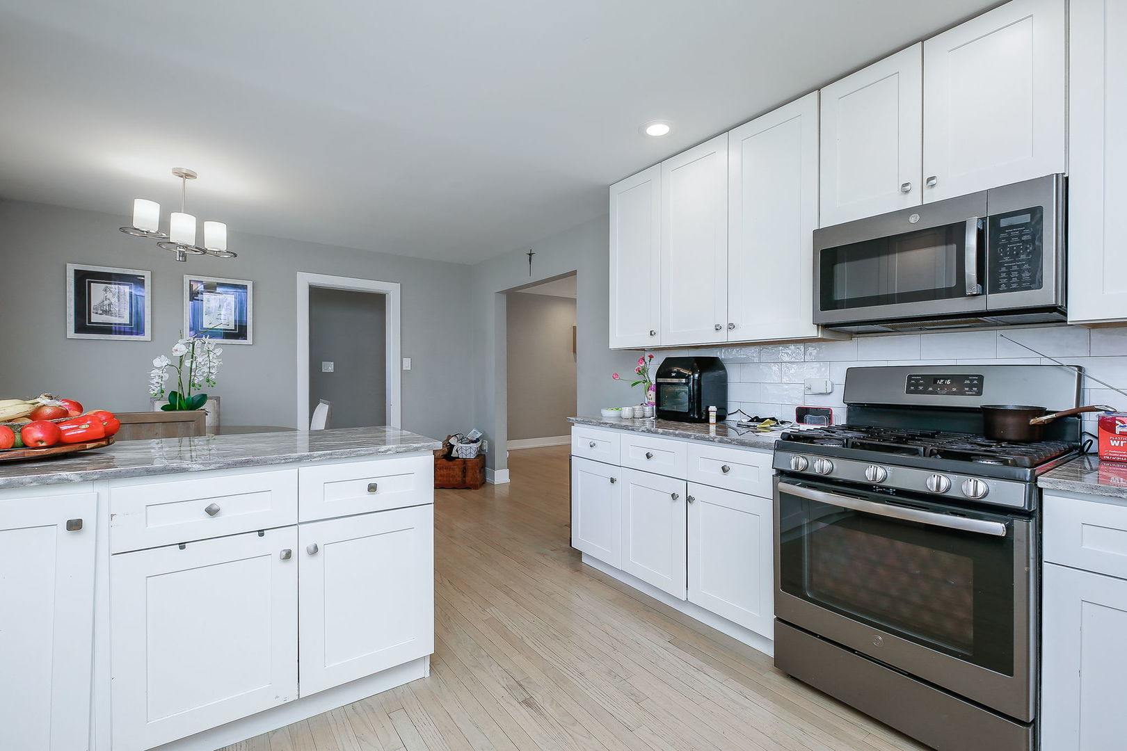 3309 York Road Oak Brook, IL 60523 - Photo 4 of 18 a kitchen with stainless steel appliances granite countertop grey cabinets a stove a sink and a microwave