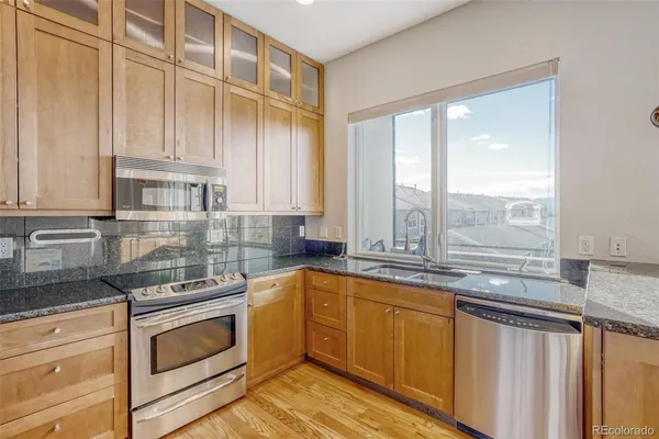 a kitchen with granite countertop a sink a stove and cabinets