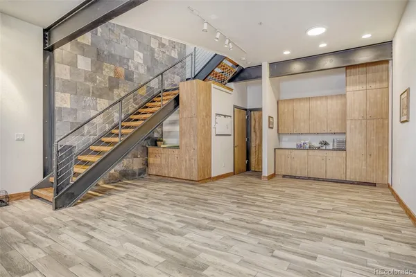 a kitchen with stainless steel appliances granite countertop a sink and cabinets with wooden floor