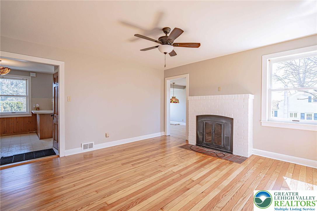 6245 Vera Cruz Road Emmaus, PA 18049 - Photo 12 of 72 an empty room with wooden floor a fireplace and windows