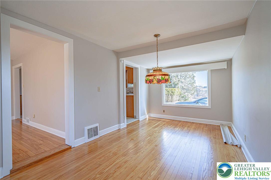 6245 Vera Cruz Road Emmaus, PA 18049 - Photo 16 of 72 a view of an empty room with wooden floor fridge and a window