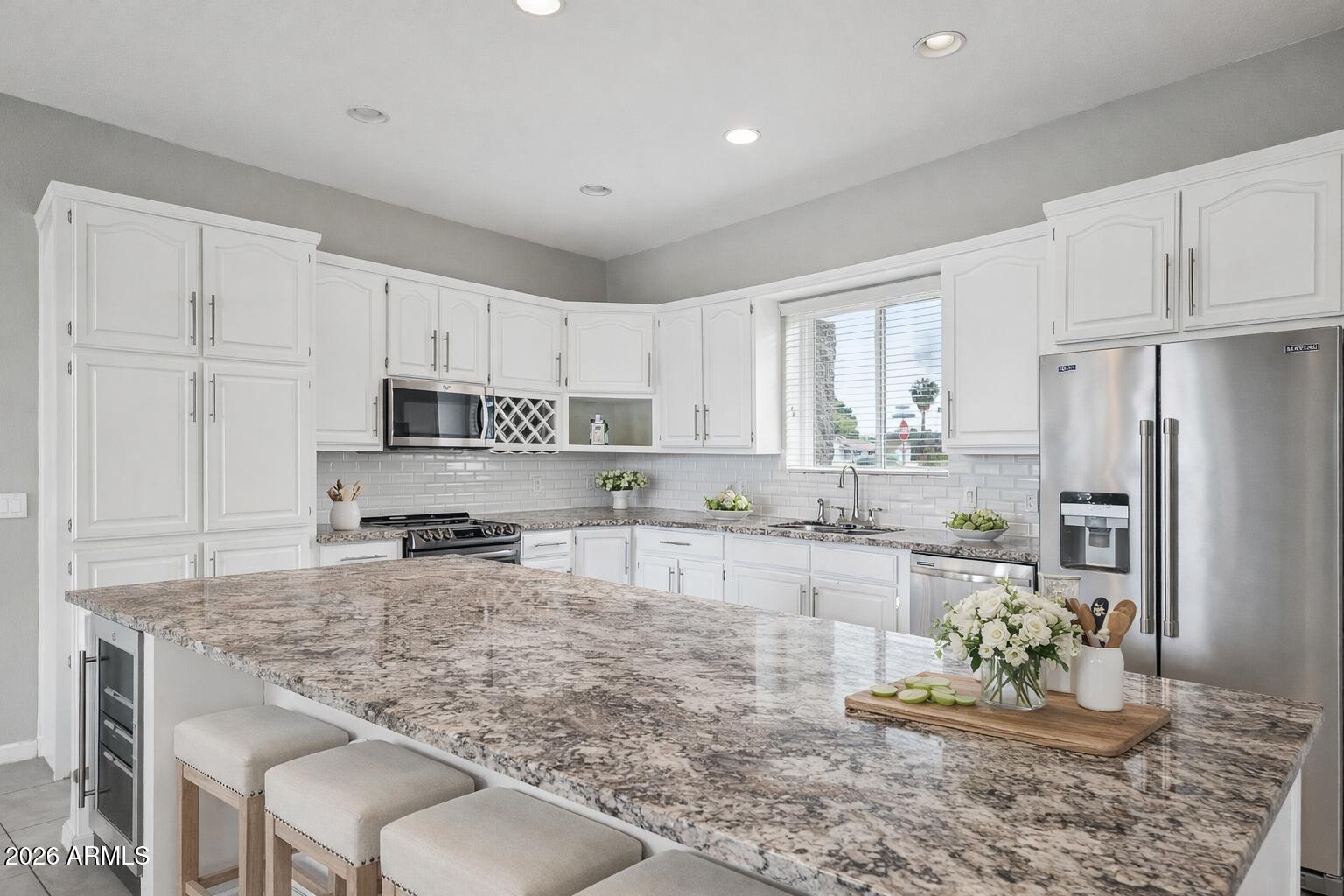 702 West Why Worry Lane Phoenix, AZ 85021 - Photo 10 of 53 a large kitchen with kitchen island granite countertop a stove a sink a refrigerator and white cabinets