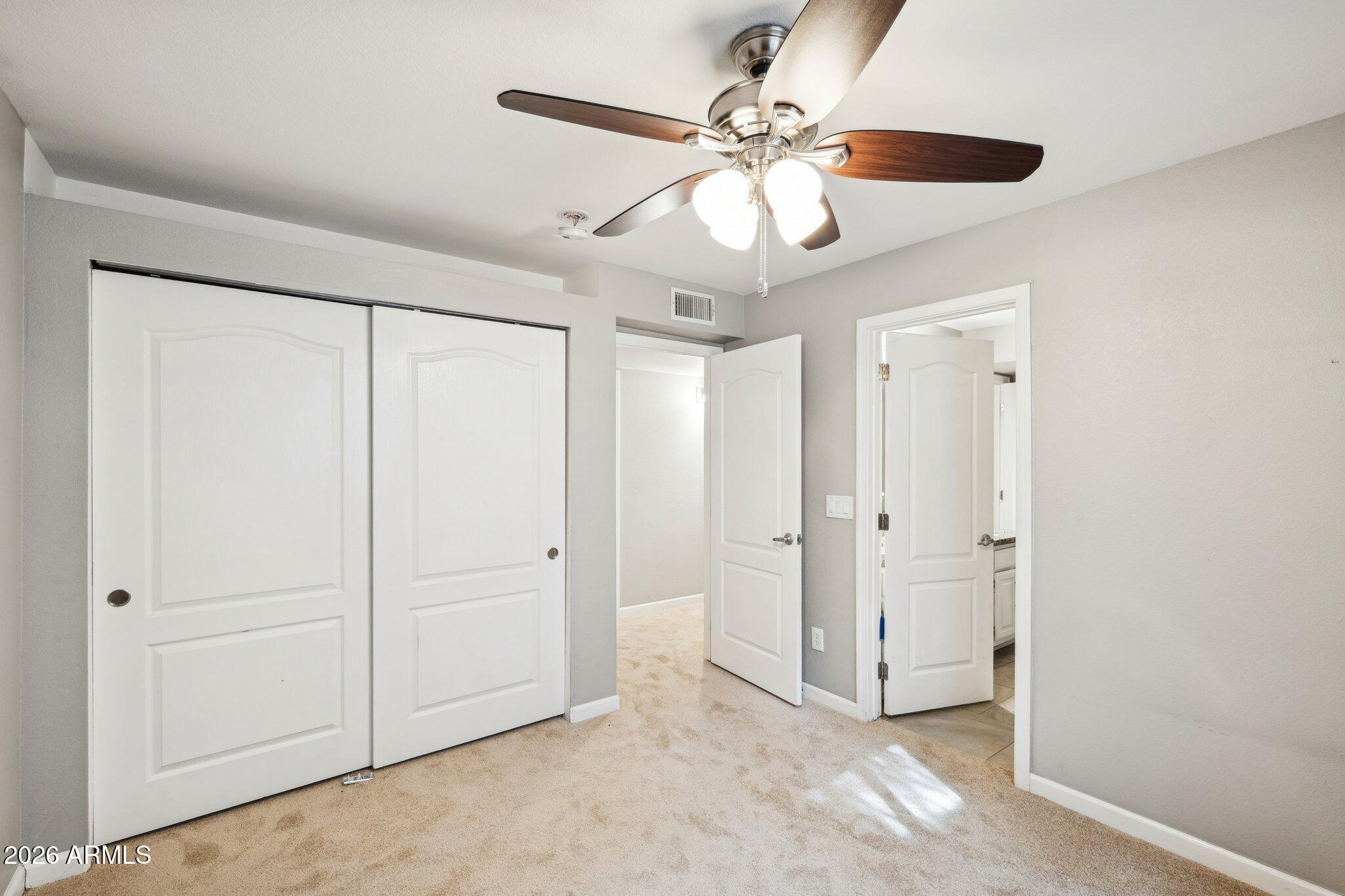 702 West Why Worry Lane Phoenix, AZ 85021 - Photo 22 of 34 an empty room with chandelier fan and windows