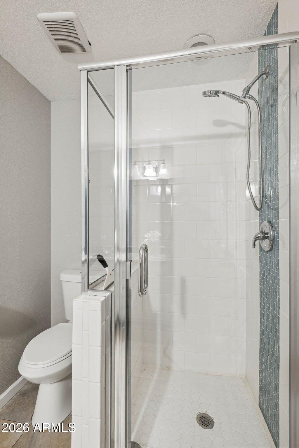 702 West Why Worry Lane Phoenix, AZ 85021 - Photo 24 of 34 a bathroom with a shower a toilet and a glass door shower