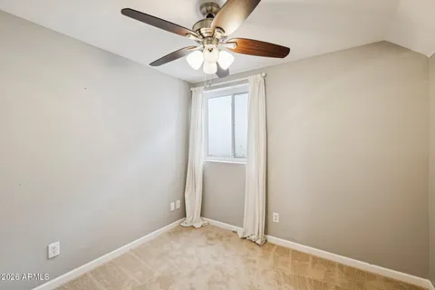 an empty room with wooden floor closet and windows