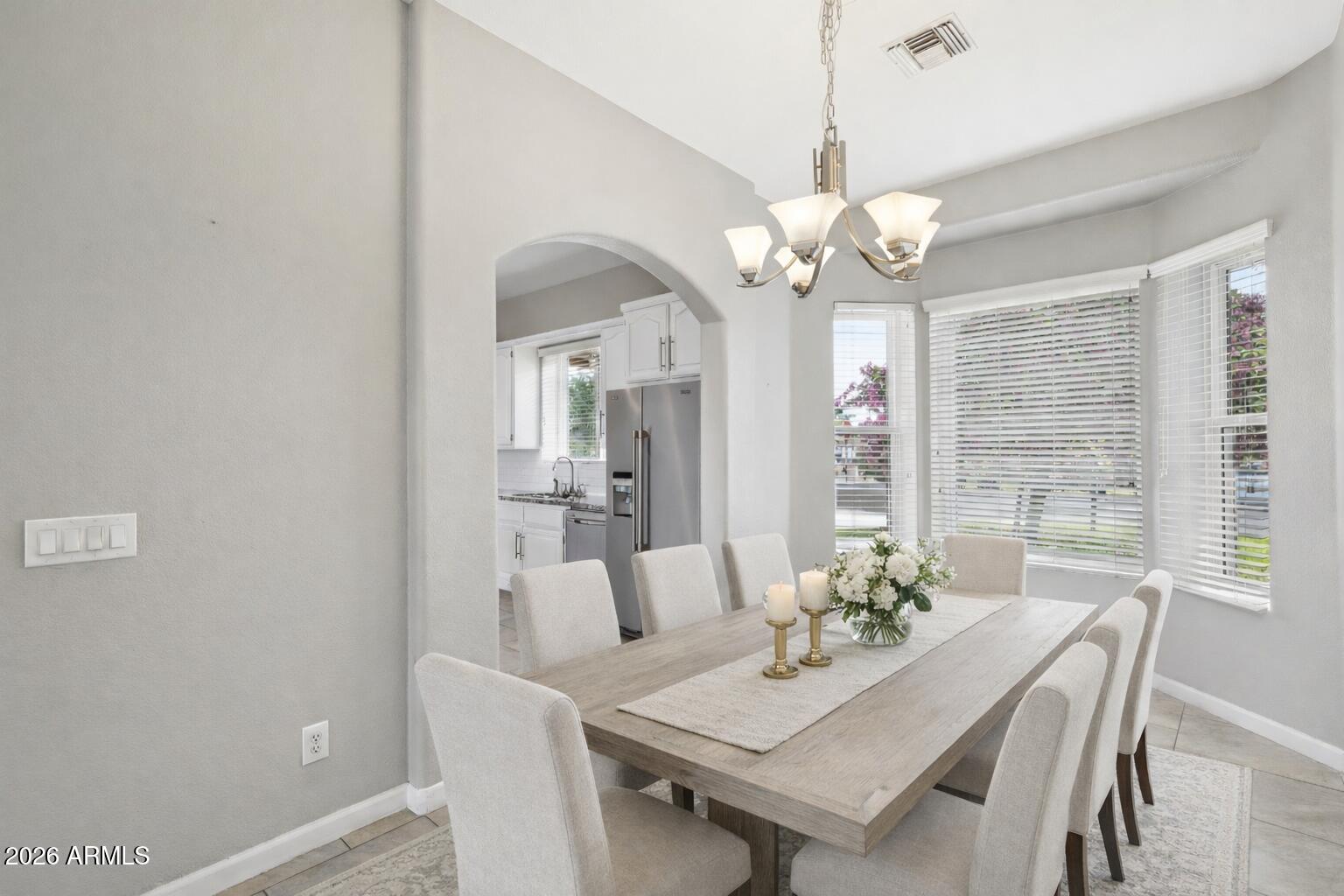 702 West Why Worry Lane Phoenix, AZ 85021 - Photo 5 of 53 a view of a dining room with furniture a chandelier and a window