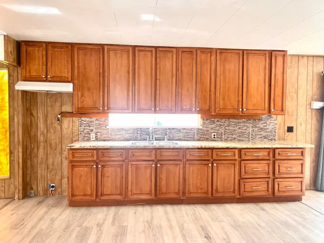 a view of a kitchen with wooden cabinets