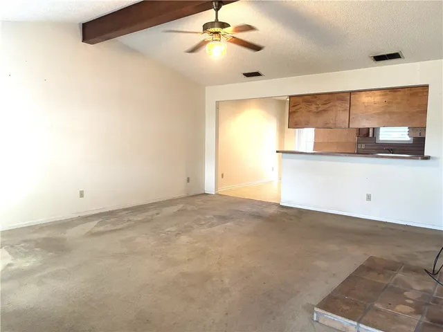 a view of a big room with chandelier fan and windows