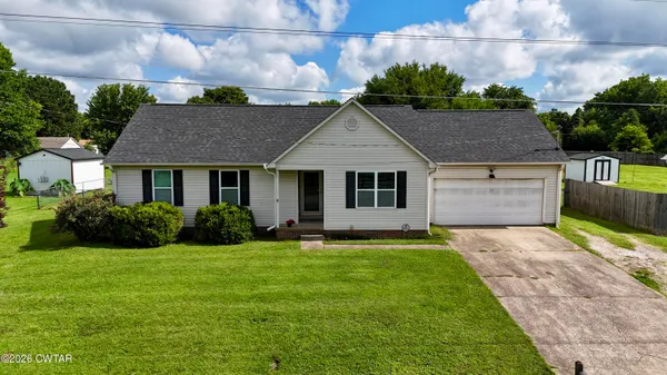 a front view of a house with a garden and yard