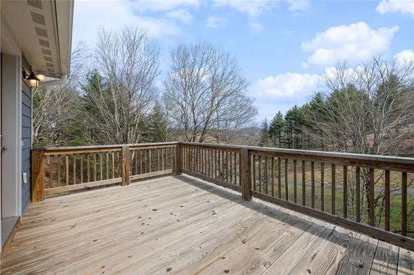 a balcony with wooden floor and trees