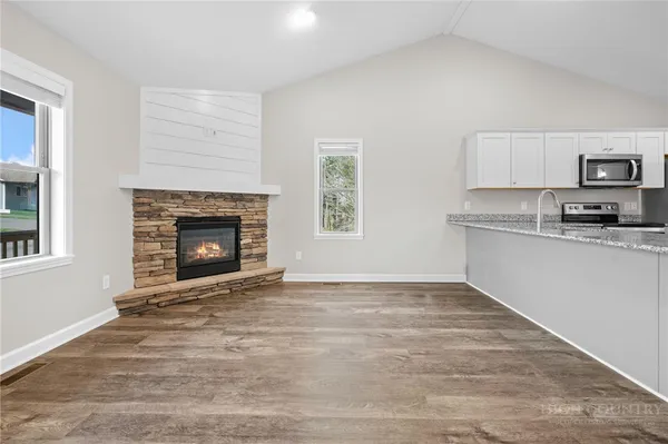 a view of kitchen with granite countertop stove top oven and cabinets