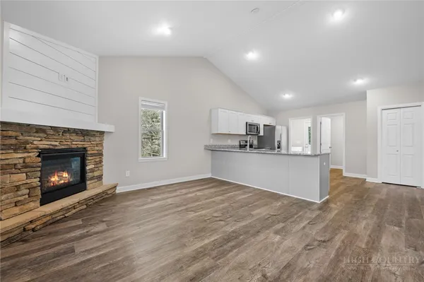 a view of kitchen with fireplace and wooden floor