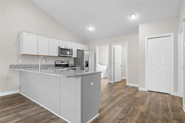a kitchen with stainless steel appliances granite countertop a stove a sink and a refrigerator
