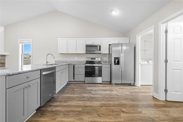 a kitchen with granite countertop a refrigerator stove top oven and sink