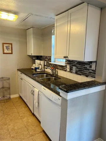 a kitchen with granite countertop a sink and a stove