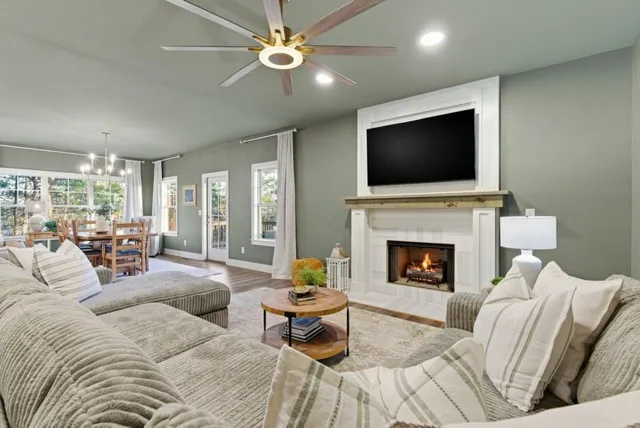 a living room with furniture a fireplace and a flat screen tv