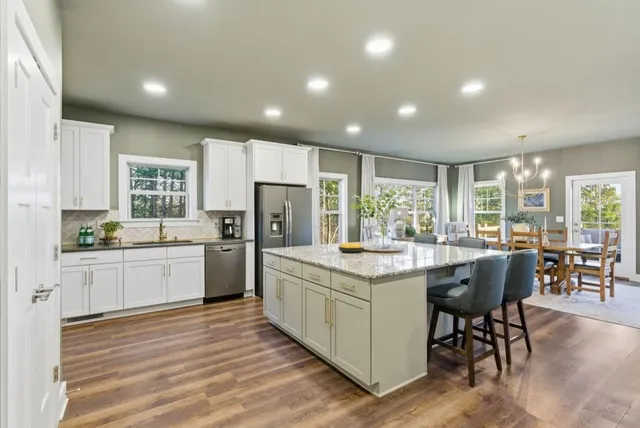 a kitchen with a table chairs refrigerator and cabinets