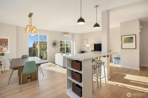a living room with furniture a flat screen tv and kitchen view