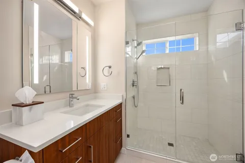 a bathroom with a double vanity sink mirror and shower