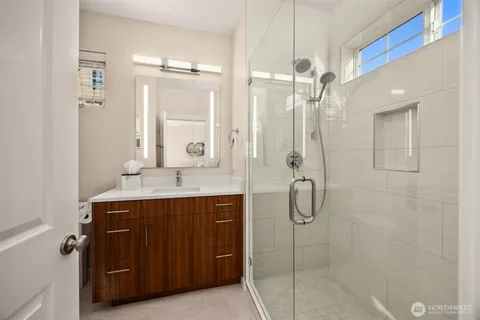 a bathroom with a shower sink vanity and mirror