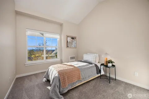 a bedroom with a bed lamp and a window
