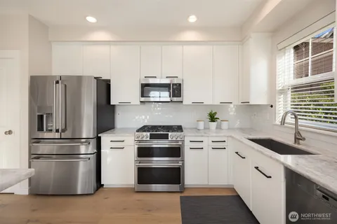 a kitchen with cabinets stainless steel appliances and a window