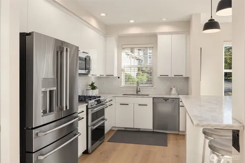 a kitchen with stainless steel appliances a refrigerator sink and stove