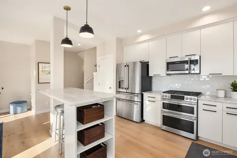 a kitchen with stainless steel appliances kitchen island granite countertop a stove and a refrigerator