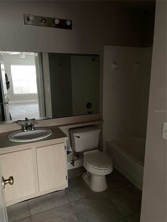 4356 South Kirkman Road, Unit 501 Orlando, FL 32811 - Photo 17 of 19 a bathroom with a granite countertop toilet sink mirror and vanity