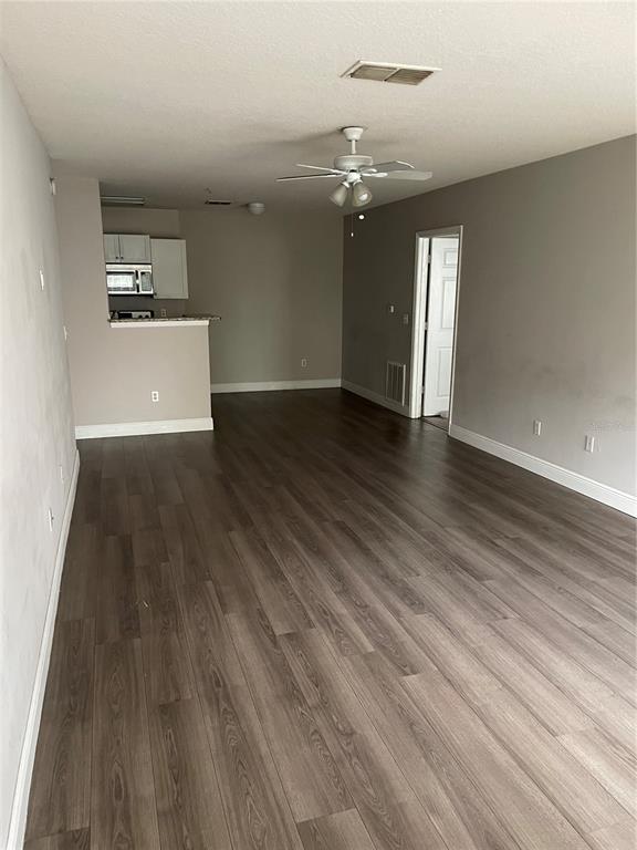 4356 South Kirkman Road, Unit 501 Orlando, FL 32811 - Photo 5 of 19 an empty room with wooden floor and windows