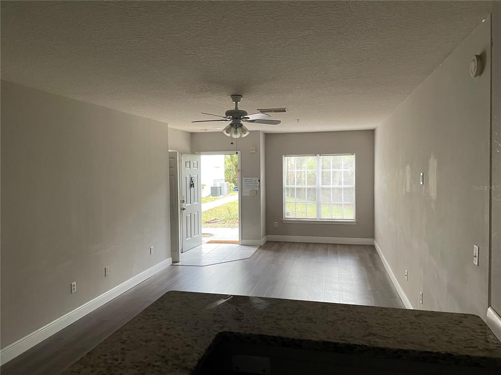 4356 South Kirkman Road, Unit 501 Orlando, FL 32811 - Photo 9 of 19 an empty room with wooden floor and windows