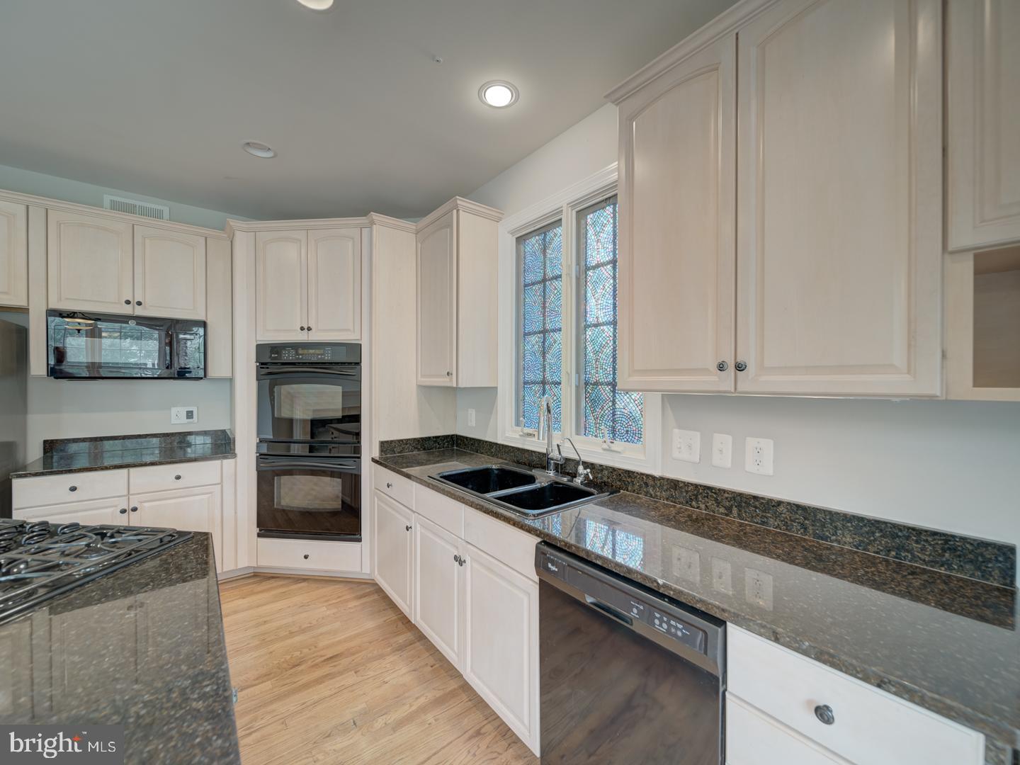 8429 Link Hills Loop Gainesville, VA 20155 - Photo 40 of 102 a kitchen with granite countertop white cabinets and stainless steel appliances