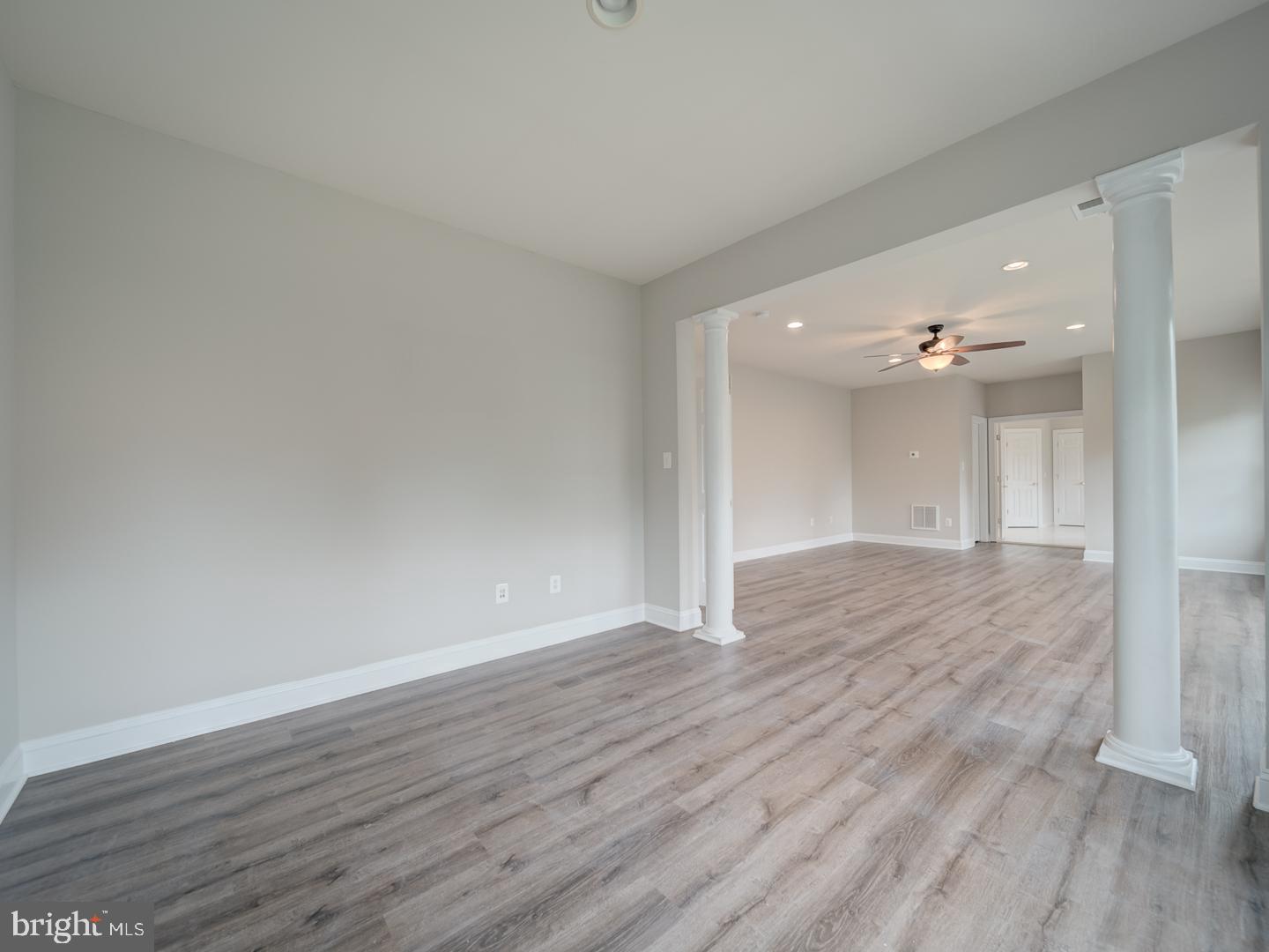 8429 Link Hills Loop Gainesville, VA 20155 - Photo 55 of 102 a view of an empty room with wooden floor and a ceiling fan