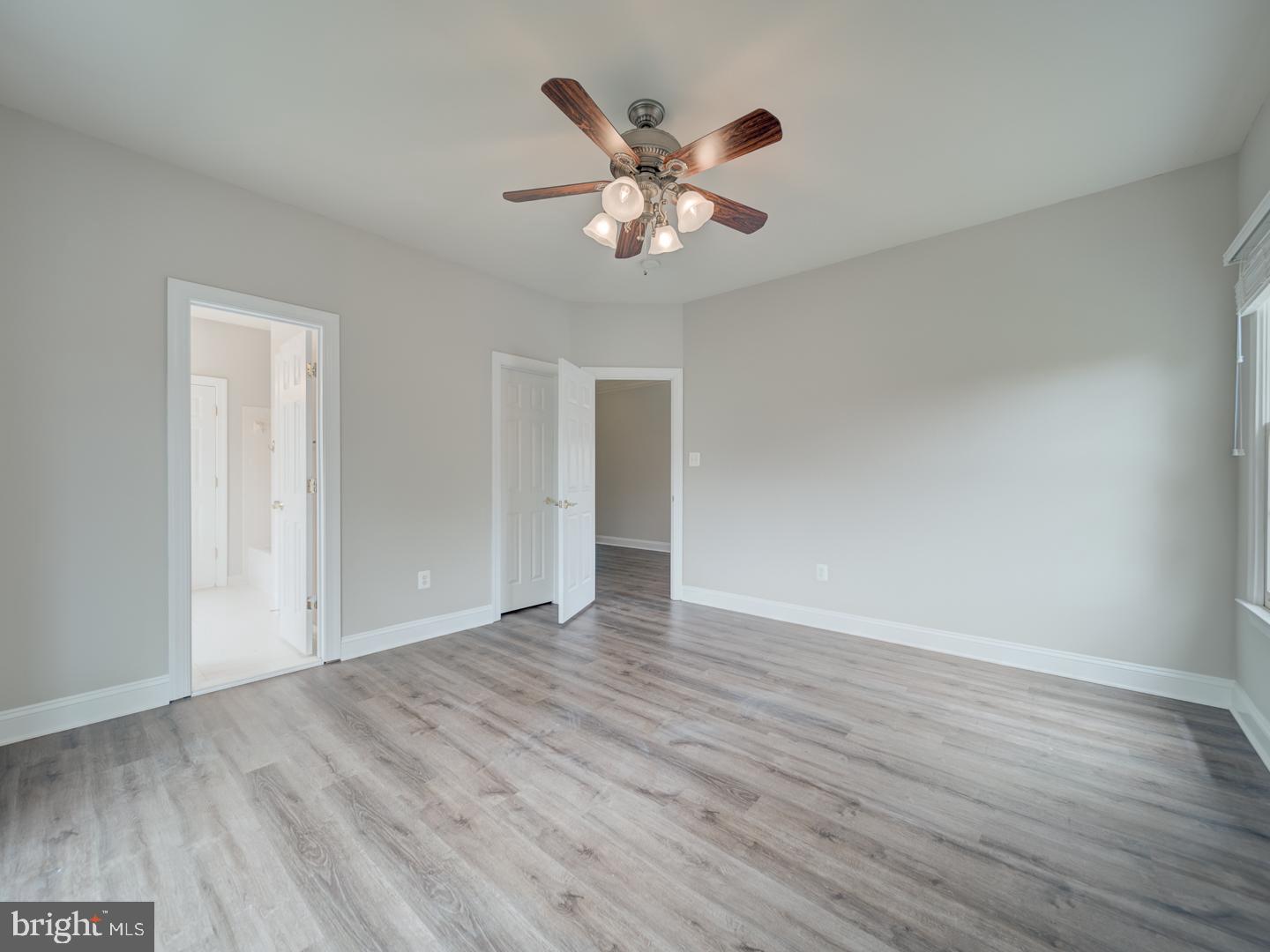 8429 Link Hills Loop Gainesville, VA 20155 - Photo 65 of 102 a view of an empty room with wooden floor and a ceiling fan