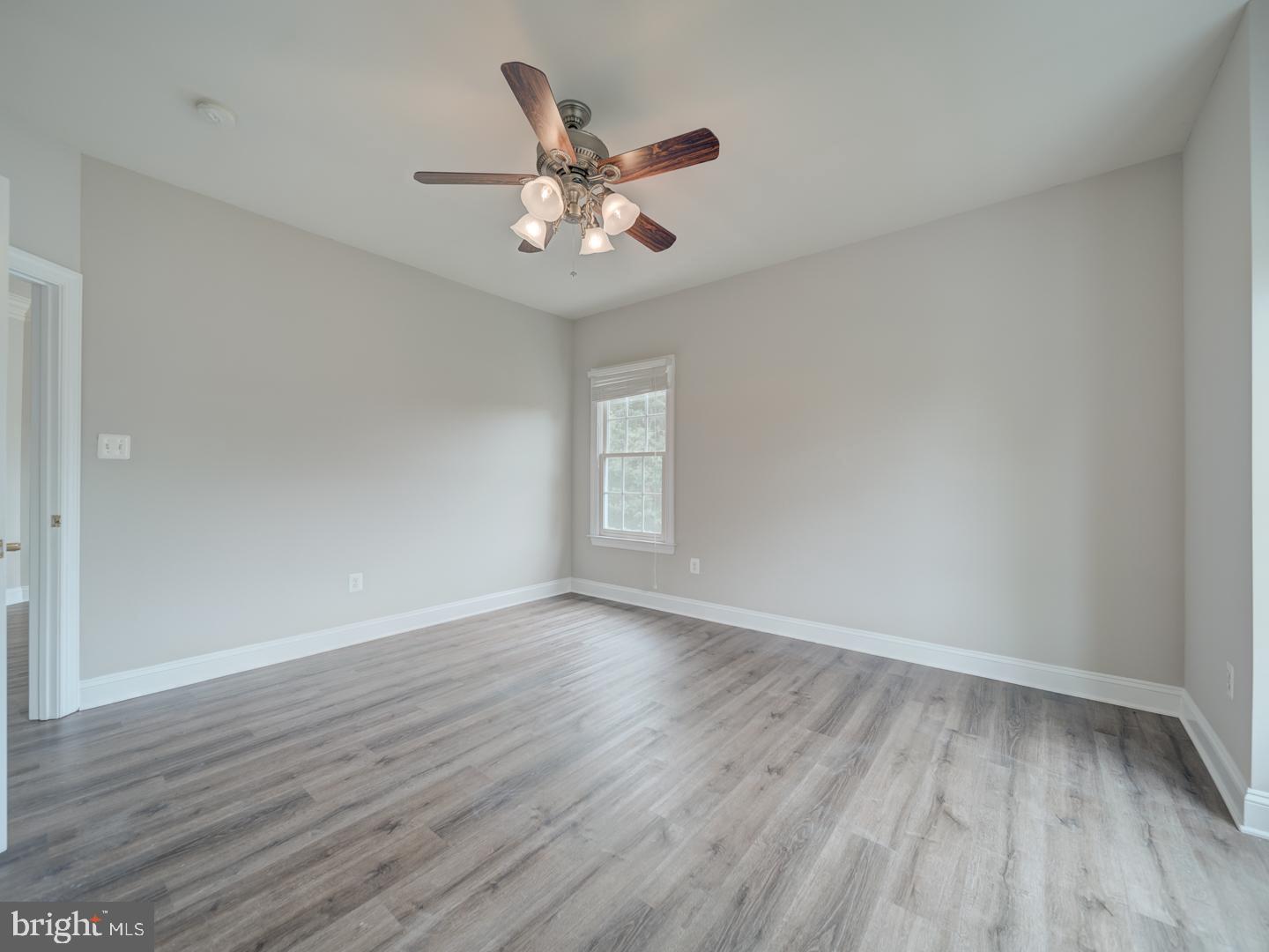 8429 Link Hills Loop Gainesville, VA 20155 - Photo 66 of 102 a view of an empty room with wooden floor and a ceiling fan