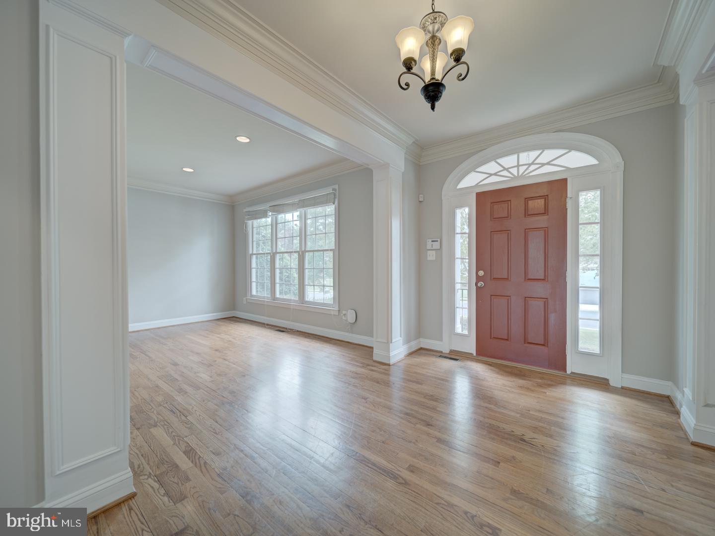 8429 Link Hills Loop Gainesville, VA 20155 - Photo 8 of 102 an empty room with wooden floor chandelier and windows