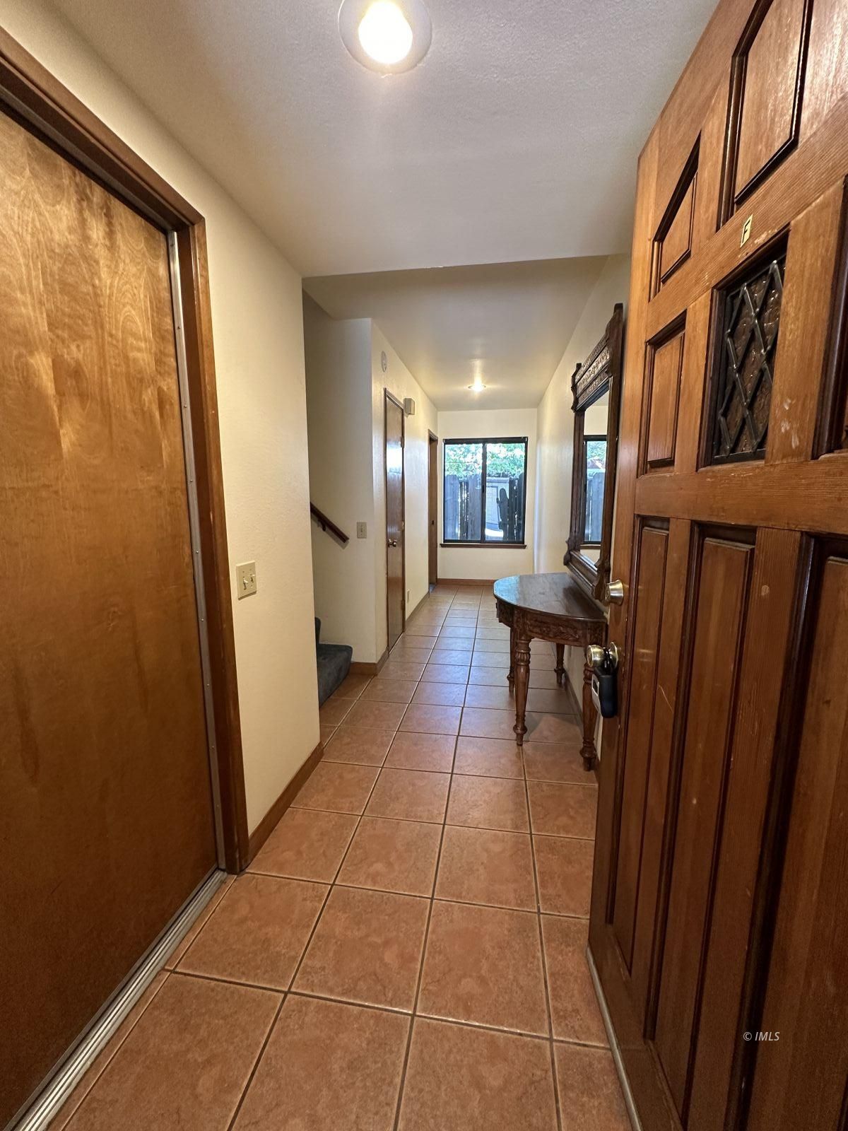 a view of a hallway with furniture and a window