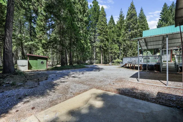 a view of a house with a wooden deck and a yard