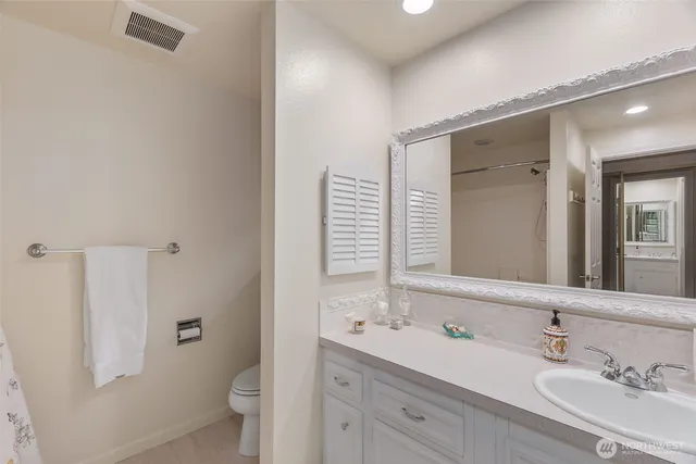 a bathroom with a double vanity sink toilet mirror and shower