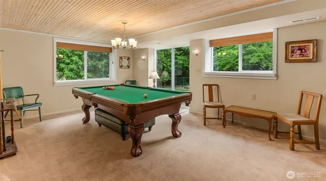a room with pool table and windows
