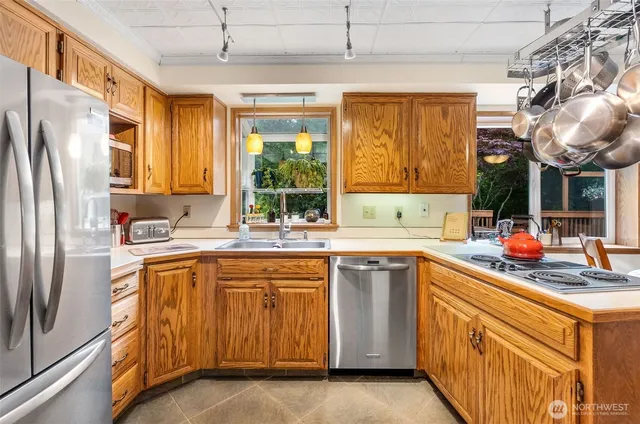 a kitchen with stainless steel appliances granite countertop a sink a stove and refrigerator
