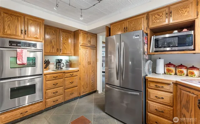 a kitchen with stainless steel appliances granite countertop a refrigerator stove and cabinets