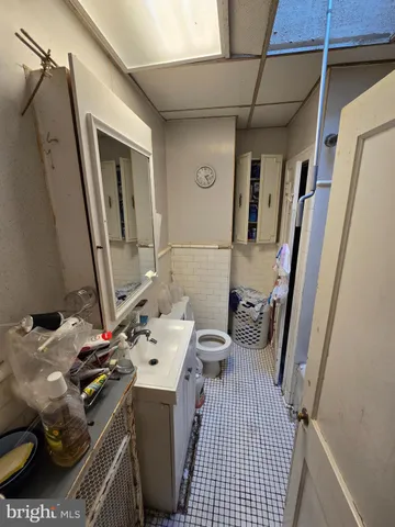 a bathroom with a sink a toilet a mirror and shower