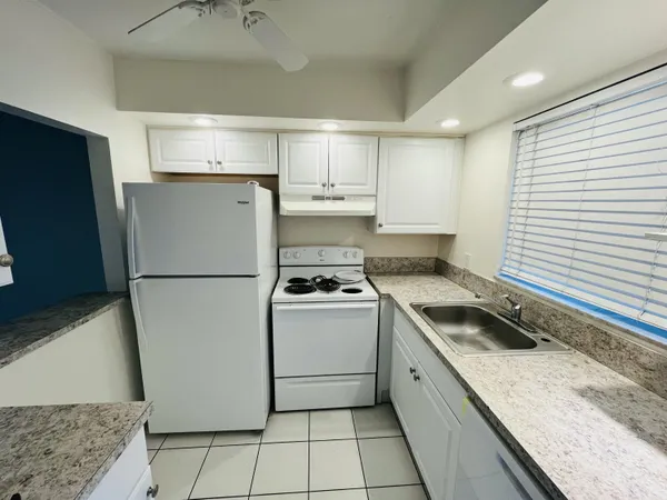 a kitchen with a stove a refrigerator and a sink