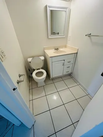 a bathroom with a toilet sink and mirror